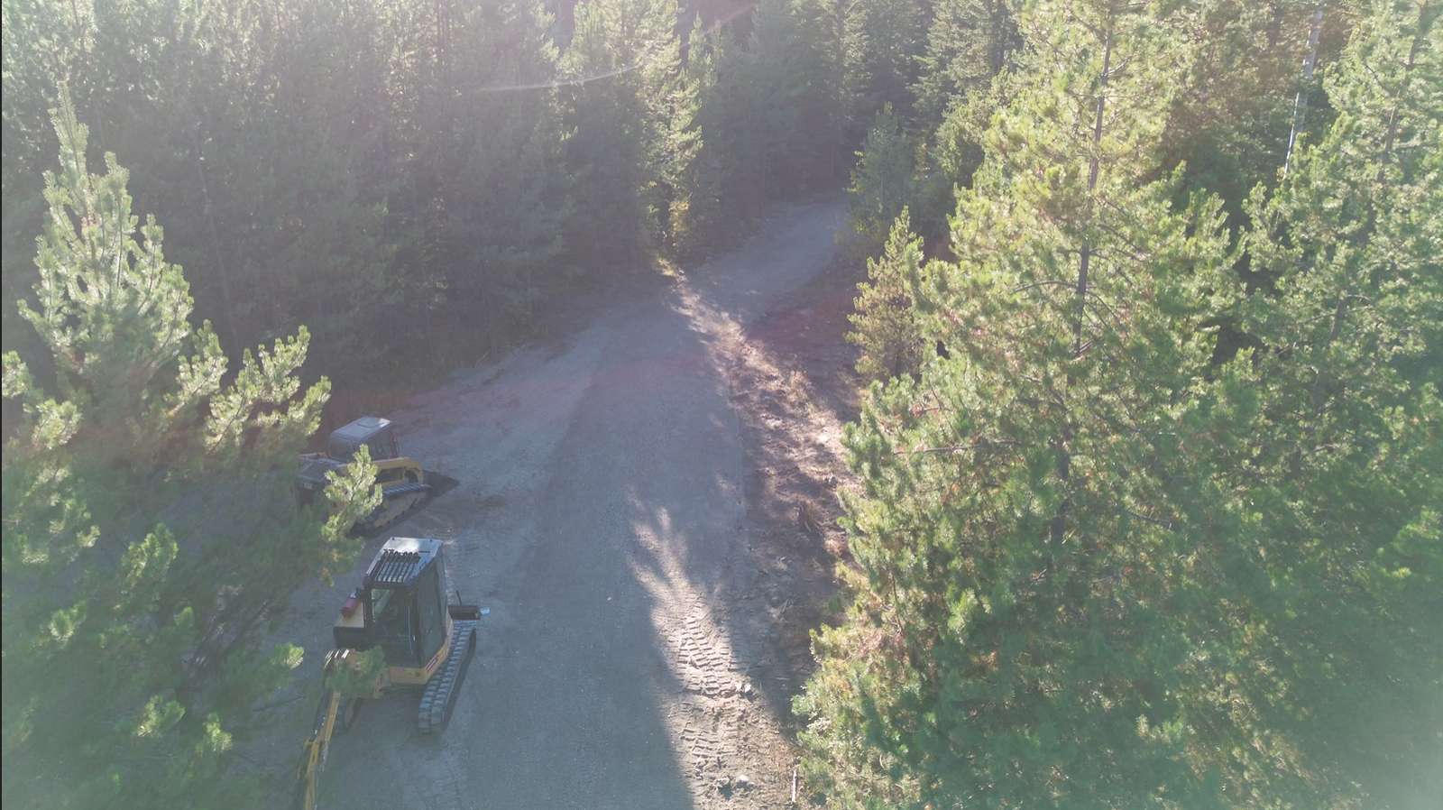 Aerial view of finished gravel access road through forest